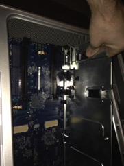 Grab board by PCI divider and pull slightly towards the front of the case to remove